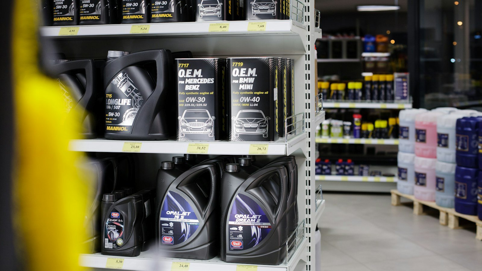 Auto parts store shelving stocked with oils and vehicle consumables